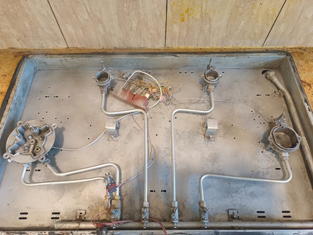Cleaned 4-burner gas stove interior tray showing restored metal