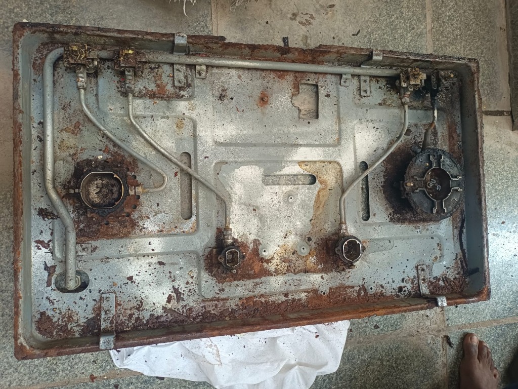 Heavily rusted and corroded stove interior tray before restoration