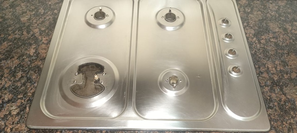 Stainless steel built-in hob top view with grates removed for maintenance